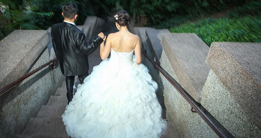 Newlyweds walking down stone stairs