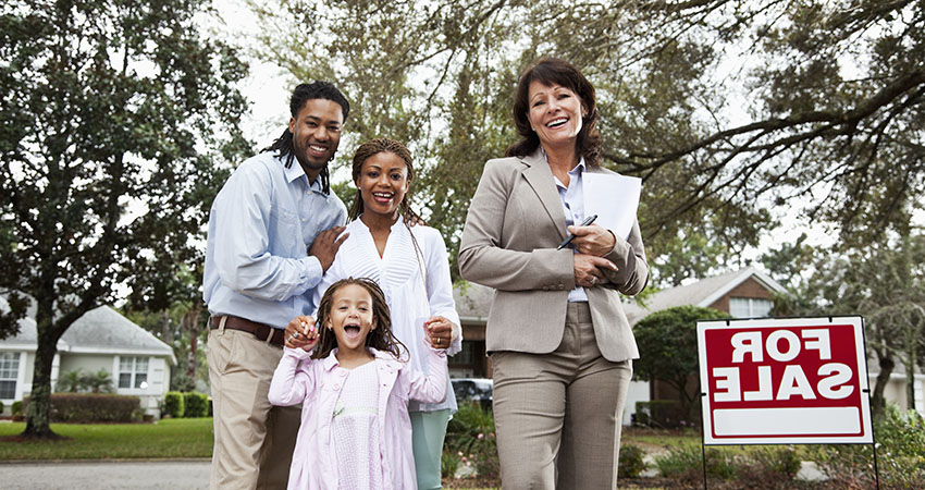 Real estate agent with family outside house